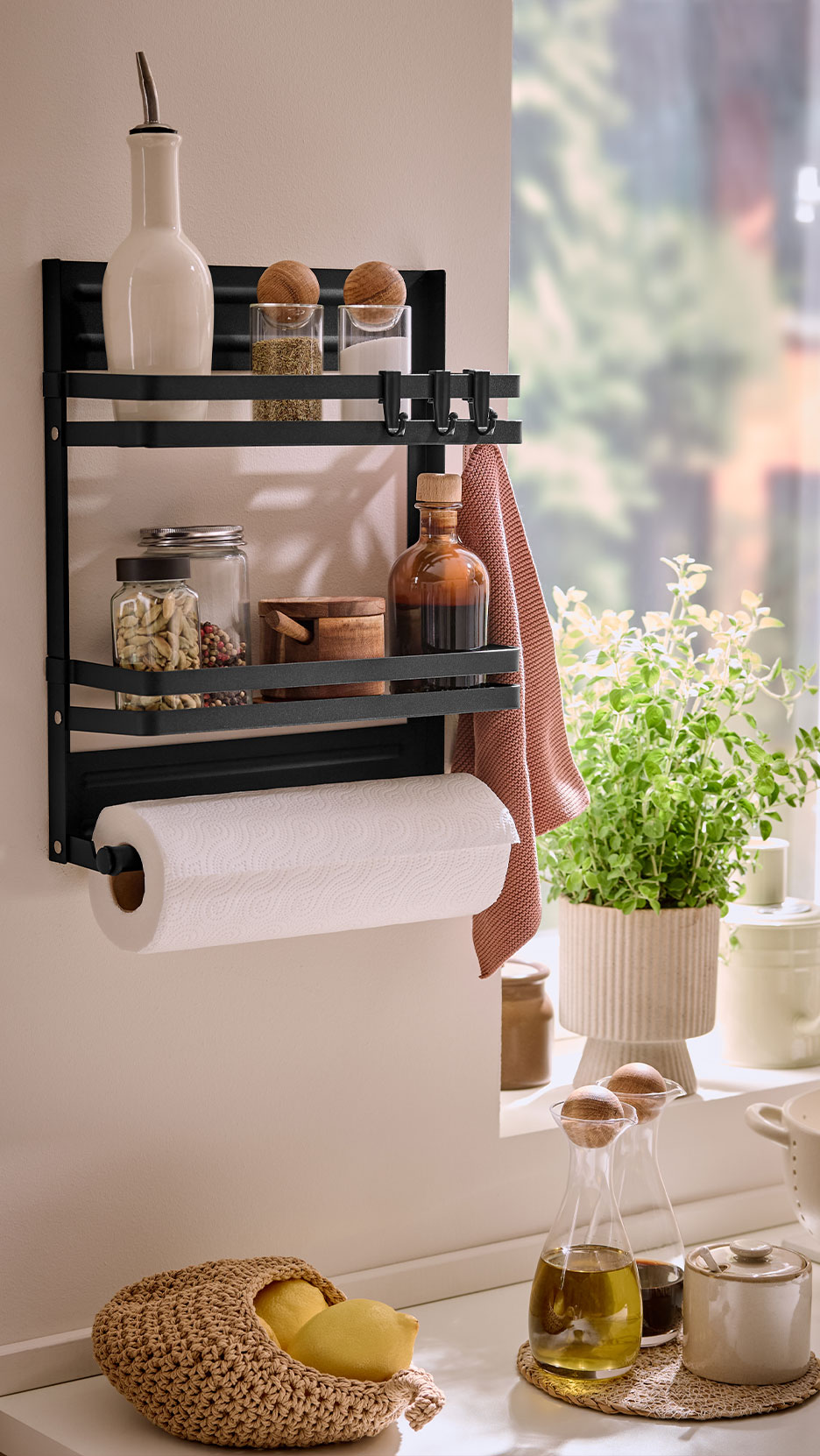 Kitchen shelf with spices, paper towels, and kitchen utensils.