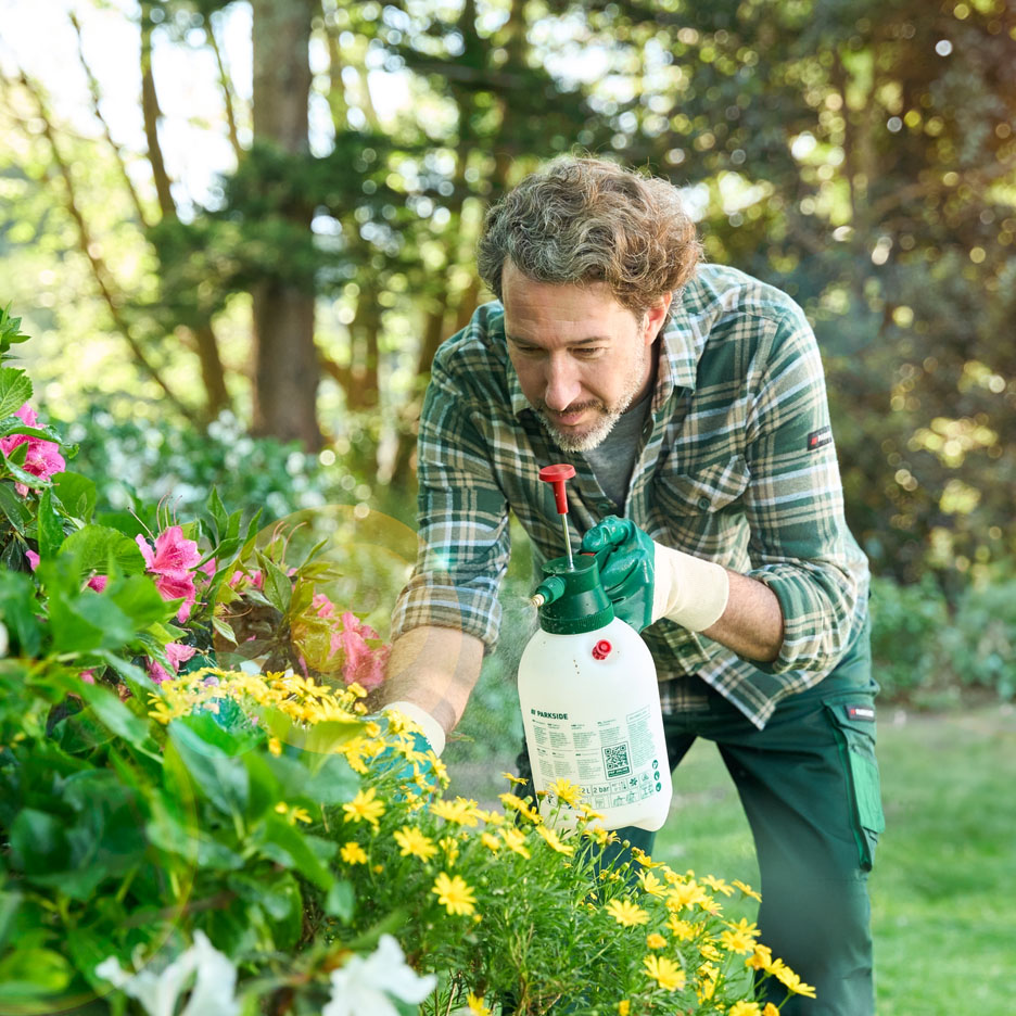 Man spraying Parkside on flowers.