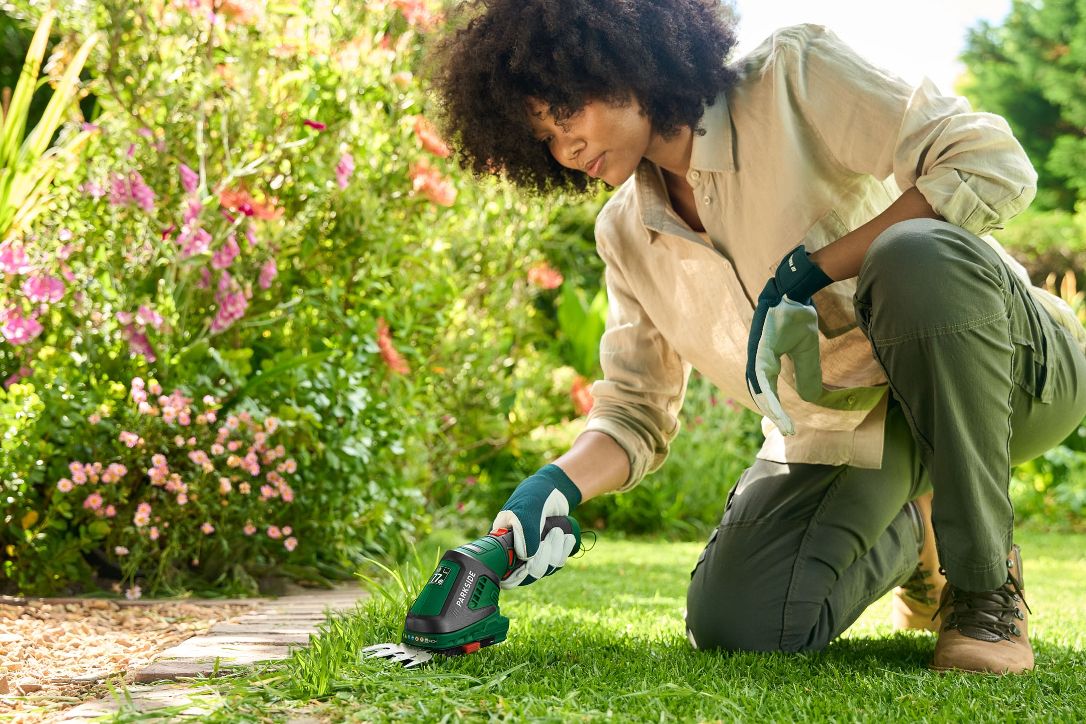 Woman trimming grass with a Parkside trimmer in the garden.